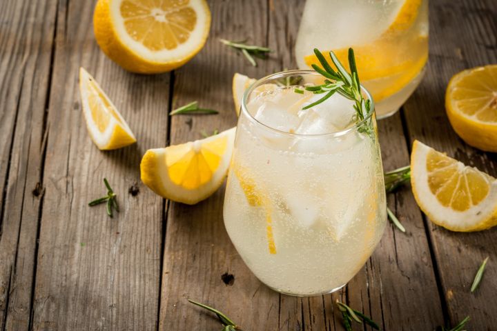White wine spritzer in a glass with lemon and rosemary. 