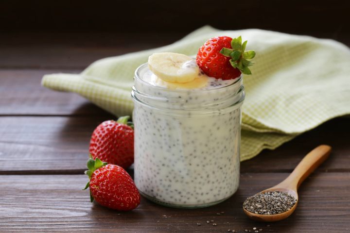 Yogurt chia seed pudding in a glass with a fresh blackberry.