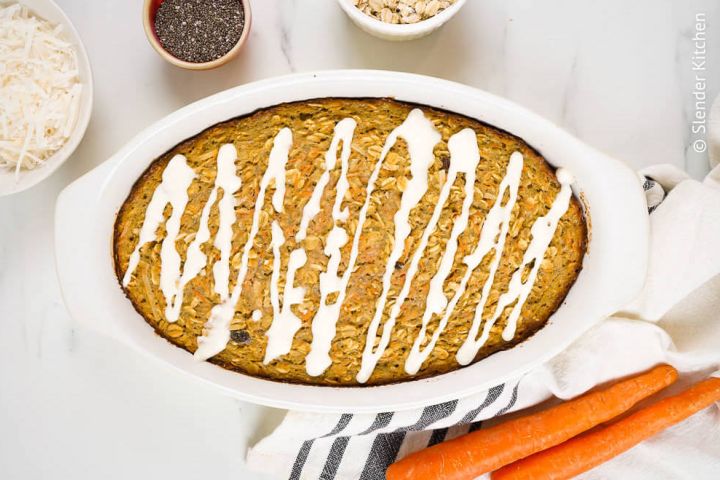 Baked carrot cake oatmeal with cream cheese icing in a baking dish.