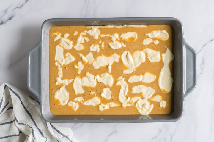 Pumpkin and cream cheese bars before being baked in a dish. 