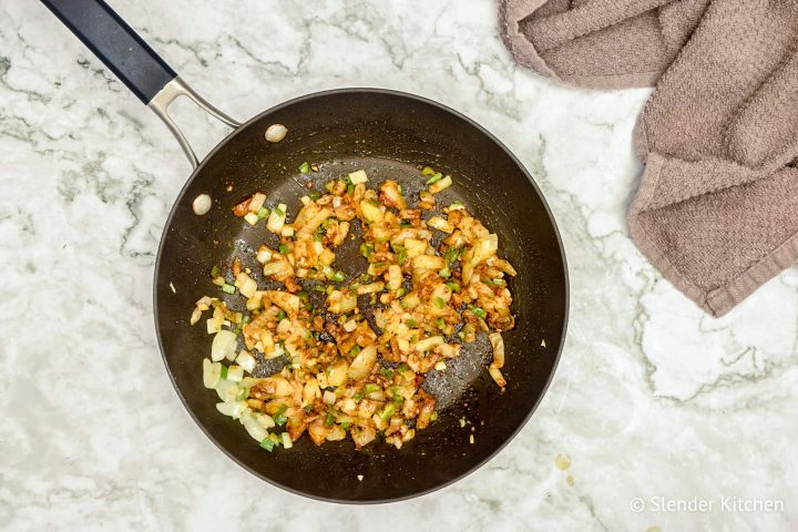 DSpices being added to onions., garlic, and ginger to make chana masala.