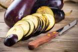 Sliced eggplant on a wood surface and knife