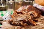 Slow cooked pulled pork shoulder on chopping board