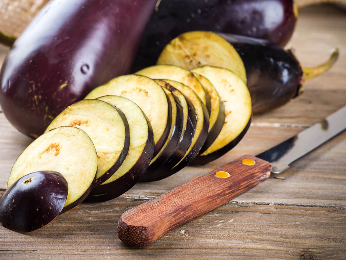 Sliced eggplant on a wood surface and knife