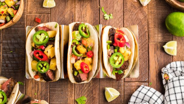Blackened steak tacos with seared steak served on flour tortillas with pineapple salsa, cilantro, and jalapenos.