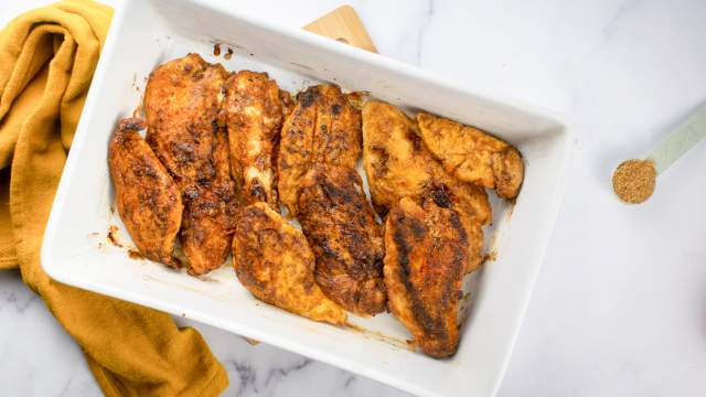 Brown Sugar Chicken in a white baking dish with extra brown sugar on the side.