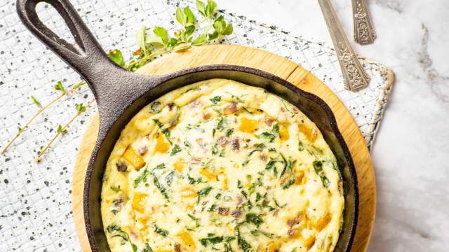 Butternut Squash and Spinach Breakfast Casserole in a cast iron skillet with a napkin.