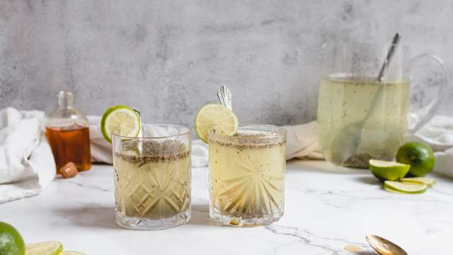 Chia fresca with water, lime juice, chia seeds, and honey in two glasses served with fresh lime slices.