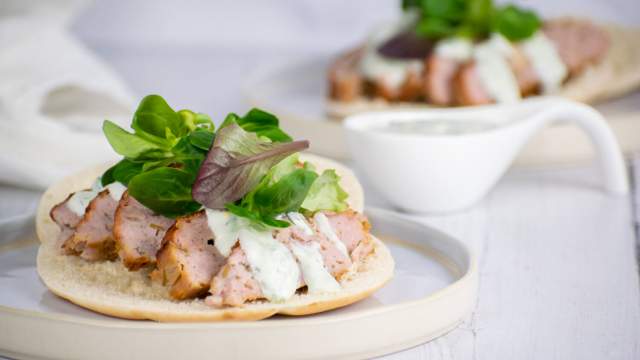 Chicken gyros with tzatziki on pita bread with lettuce.