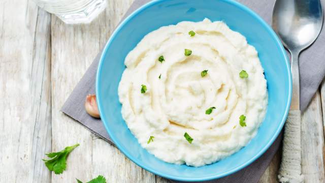 Easy mashed cauliflower in blue dish with parsley.