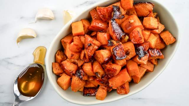 Roasted sweet potatoes with garlic cloves and a spoonful of honey.