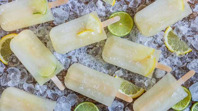 Lemon lime popsicles with fresh lemon and lime slices on a bed of ice.