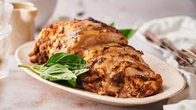 Crockpot boneless turkey breast sliced on a plate with homemade gravy.