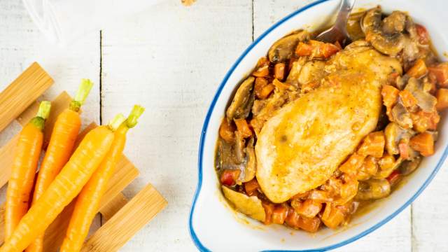 Slow Cooker Paprika Chicken in a dish with red peppers and mushrooms.