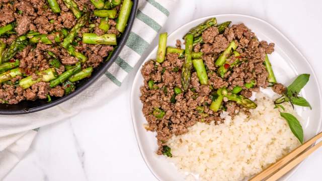 Thai Basil Ground Beef on a plate with rice and a skillet.